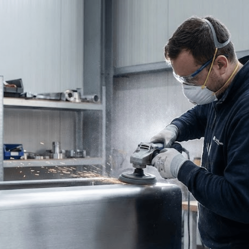 Metallbauer schleift Edelstahl mit moderner Technik bei Aquarius Industries Wildeshausen